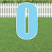Light blue yard card letter O with white outline and mounting stakes, displayed on grass with a white picket fence in the background.