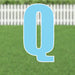 Light blue letter Q yard card with white outline and base, displayed against a white picket fence and green grass background.