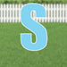 Light blue letter S yard sign with white outline and metal stakes, displayed on a grass lawn with white picket fence in background.