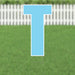 Bright blue letter T yard sign with white border and metal stakes, displayed on a grass lawn with white picket fence in background.
