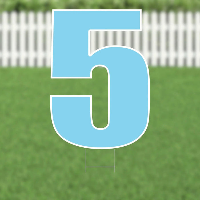 Large light blue number 5 yard card with white outline and metal stakes, displayed on green grass with white picket fence background.
