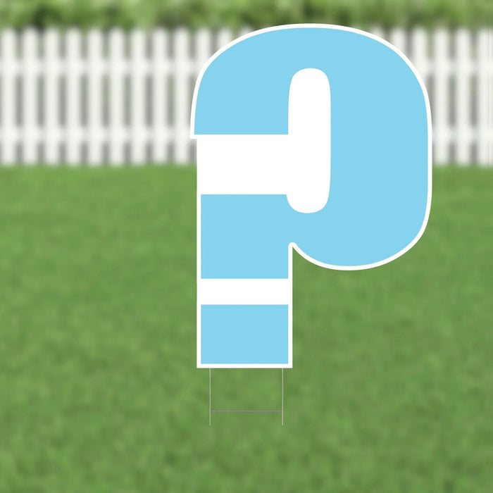 Large blue and white yard sign shaped like a dollar sign, displayed on grass with a white picket fence in the background.