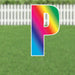 Colorful yard sign letter P with a rainbow gradient from pink to red, orange, yellow, green, and blue, featuring a white outline and metal stakes for outdoor display.