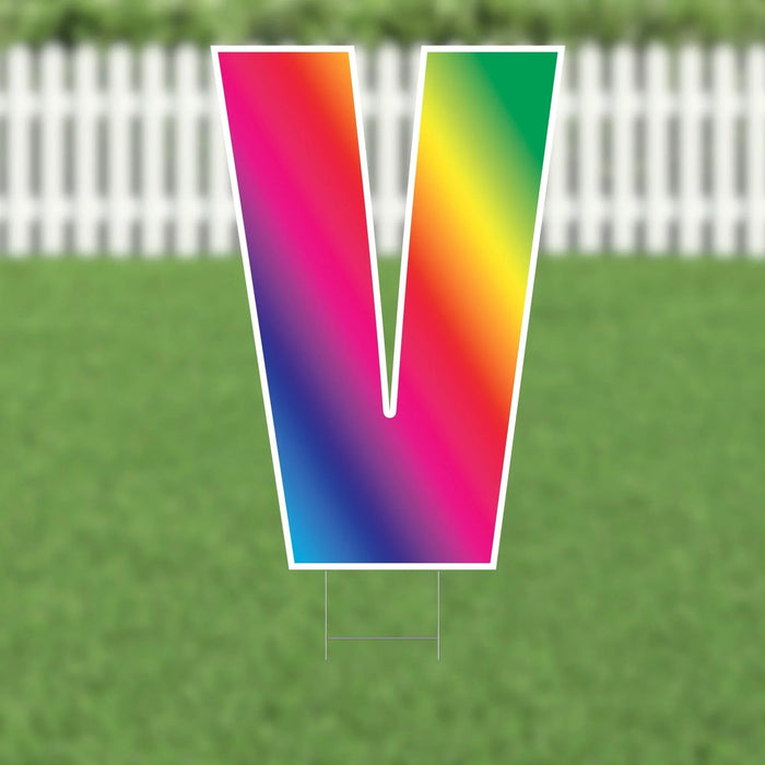 Colorful letter V yard sign with a vibrant rainbow gradient transitioning through pink, orange, yellow, green, and blue, featuring a white border and metal stakes.