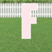 Pink letter F yard sign with white border and metal stakes, displayed on green grass with white picket fence in background.