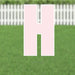 Pink yard card letter H displayed against a green lawn backdrop with a white picket fence.