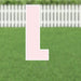 Pink letter L yard sign with white border and metal stakes displayed on a grass lawn with white picket fence background.