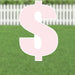Large pink dollar sign yard decoration with white outline and metal ground stakes, displayed on green grass with white picket fence background.