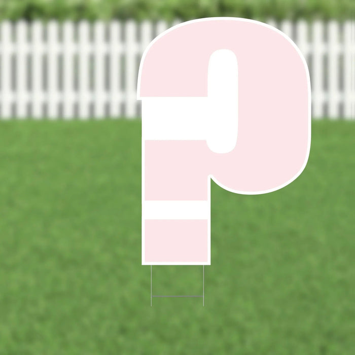 Pink and white yard sign shaped like the number nine with horizontal stripes, displayed against green grass and white picket fence background.