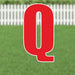 Red letter Q yard sign with white border and mounting stakes, displayed on grass with white fence background.