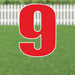 Large red number 9 yard sign with white outline and metal stakes, displayed on a lawn with white picket fence in the background.