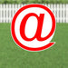 Red circular yard sign with a white @ symbol displayed against a green lawn and white picket fence background.